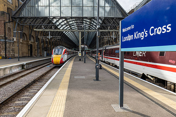 This photo captures the bustling energy of Earls Court Station at night. The station is aglow with light, casting a warm and inviting glow onto the scene. In the foreground, a train is streaking by, leaving a motion blur in its wake. The train's speed and movement are captured in the photo, creating a sense of momentum and motion. We see the station's architecture, with its clean lines and modern design, contrasting with the speed and movement of the train. This photo captures the essence of the vibrant energy and constant motion that defines urban life, making Earls Court Station a perfect symbol of the city at night.
