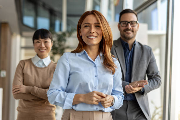 Smiling businesswoman leading diverse team in modern office