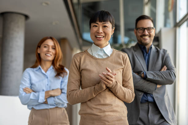 istock Happy business team smiling at camera in office hallway 2205664619