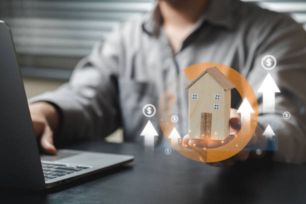 istock Model House in Hand with Financial Growth Concept in Office Setting 2205664752
