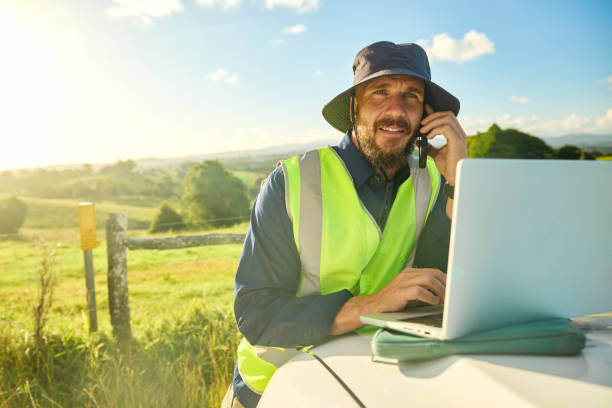 istock Australian engineer planning construction project in rural landscape using laptop and phone 2205665823