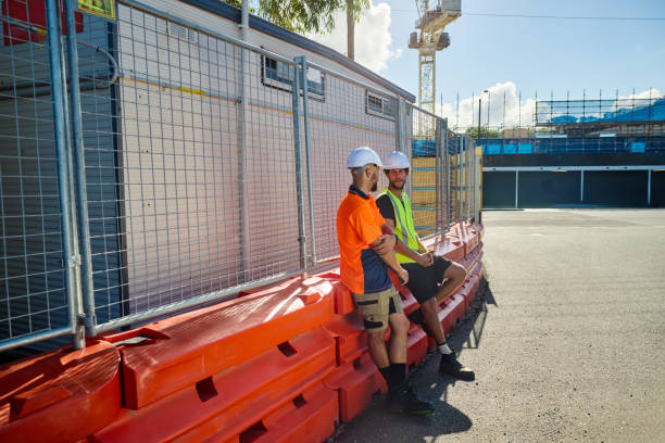istock Engineers discussing building plans at construction site in australia 2205665858