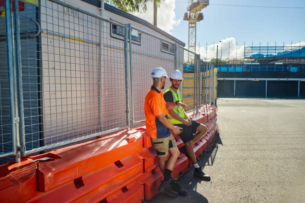 istock Engineers discussing building plans at construction site in australia 2205665874