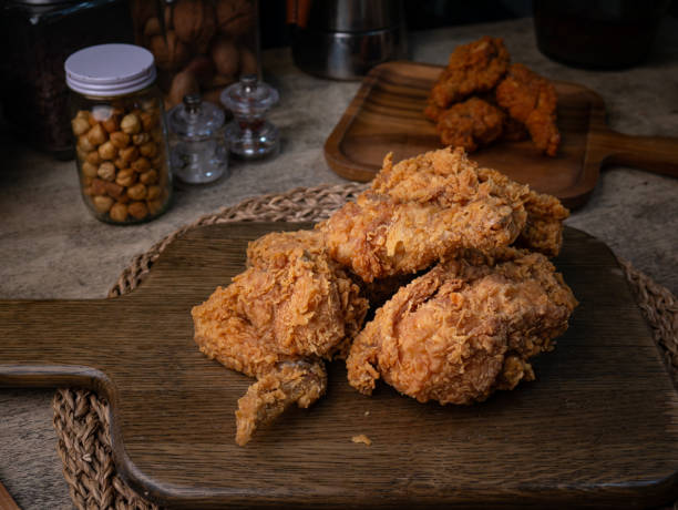 istock Crispy Fried chicken on a wooden plate Set on dark dinning table. 2205666554