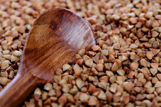 Raw buckwheat grains with wooden cooking spoon