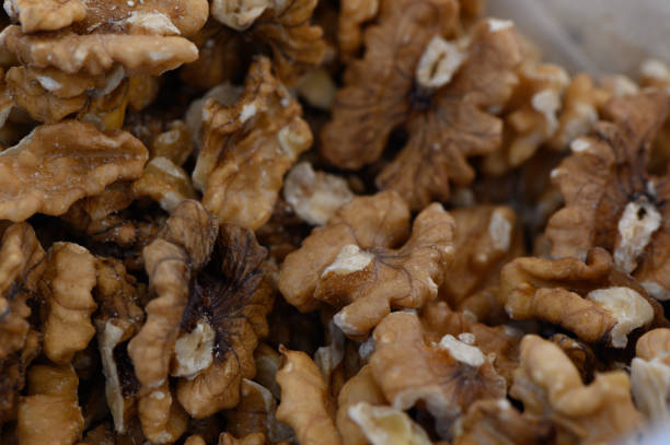 A close-up view showcases beautifully cracked walnut halves, their rich, nutty texture inviting creativity in recipes. Perfect for snacking, baking, and cooking.