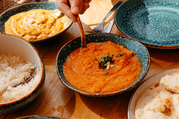 istock man serving some chicken tikka masala 2205669309