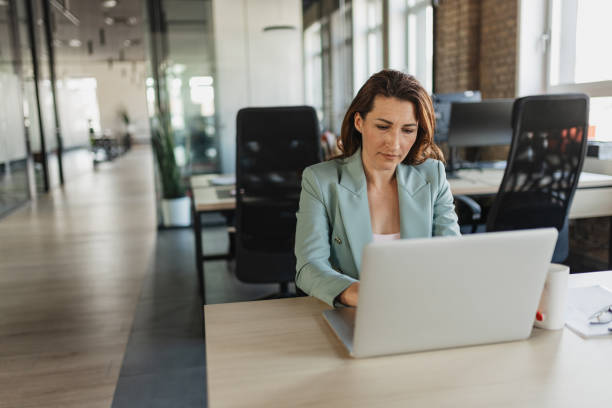 istock Serious Woman Concentrating on Laptop in Office Space 2205672499