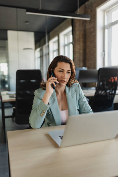 istock Professional woman talking on phone in office space 2205672529