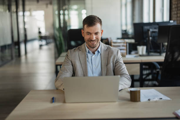 istock Cheerful Man Working on Laptop in Office Environment 2205672610