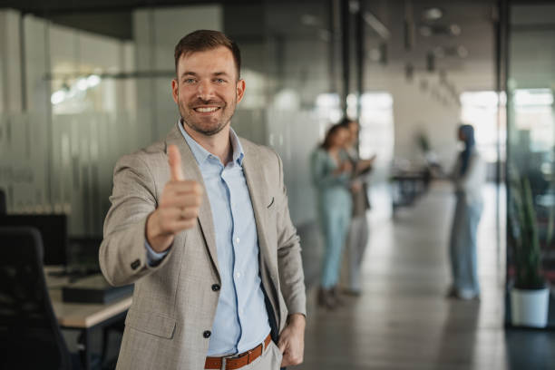 istock Smiling professional giving a thumbs up in office 2205673466