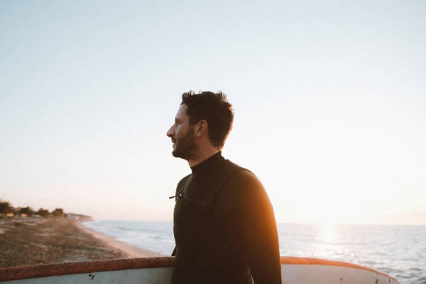 istock Male surfer holding a surfboard at the beach 2205673943