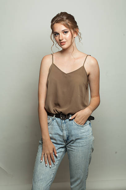 istock Posing fashion model woman standing against white studio wall background 2205674416