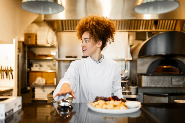 istock Female Cook Serving a Delicious Plate Using Counter Restaurant Ring Bell 2205674987