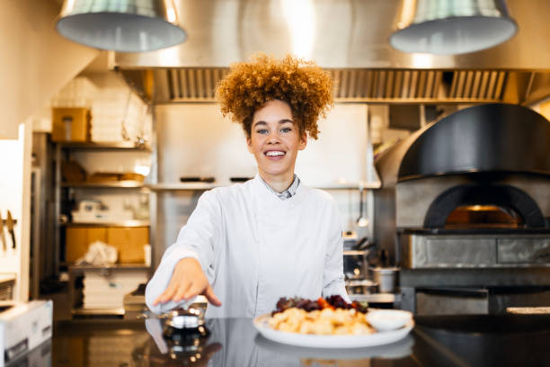istock Smiling Chef Presenting a Meal and Ringing the Counter Bell 2205675031