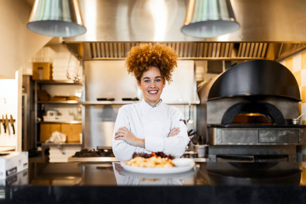 istock Proud Woman Chef Displaying a Freshly Cooked Dish 2205675199