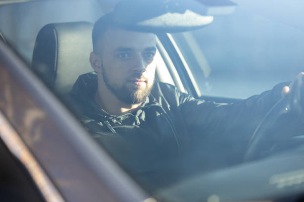 istock A handsome man sits focused behind the wheel, driving a car 2205676606
