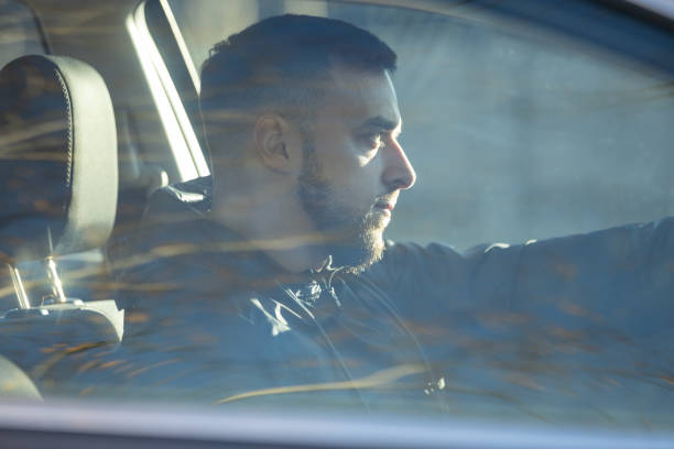 istock A handsome man sits focused behind the wheel, driving a car 2205677510