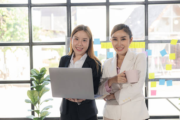 istock Two Asian women talk, consult, discuss work with presentation of new project idea, analyze business marketing plan. 2205686344