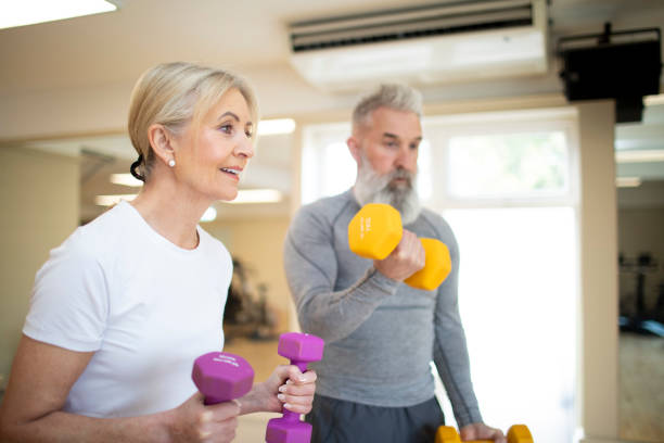 istock Mature woman with her partner exercising with dumbbells 2205687798