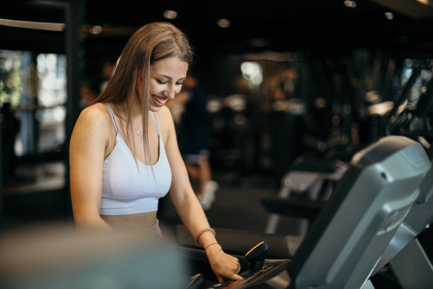 istock Young Woman Adjusting Treadmill for Cardio Workout 2205691999