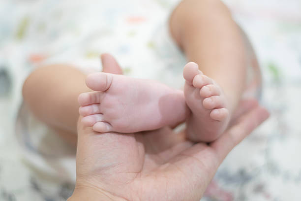 istock Baby's foot is being held by a parent 2205692016