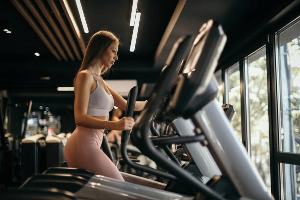 istock Woman Working Out on Elliptical Machine 2205692703