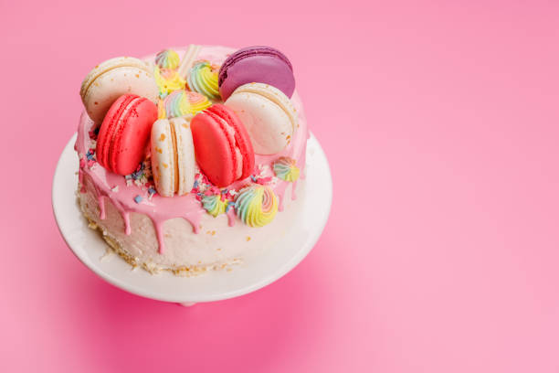 Mini birthday or anniversary cake number one candle is burning, isolated on pink background, copy space.