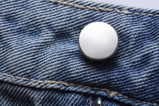 Focus-stacked macro photo of denim blue jeans with brass button and zipper detail.