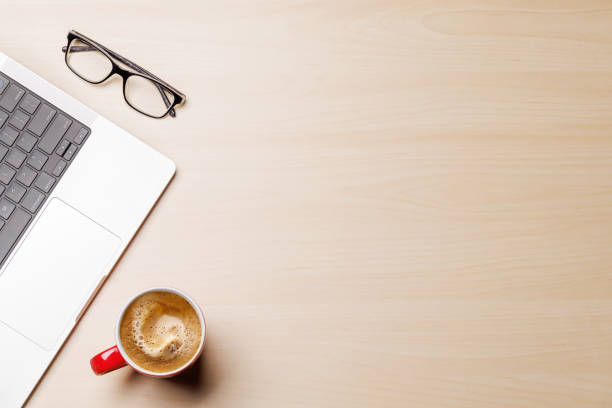 A clean and minimal desk setup featuring a laptop and a coffee cup