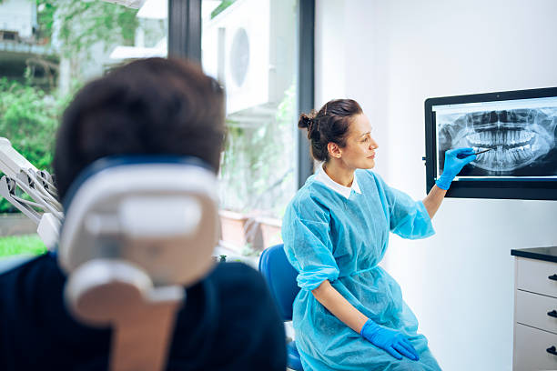 istock Dentist showing x-ray image to her patient. 2205696126
