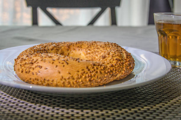 Bagel with sesame seeds on a plate close-up on a table in the room