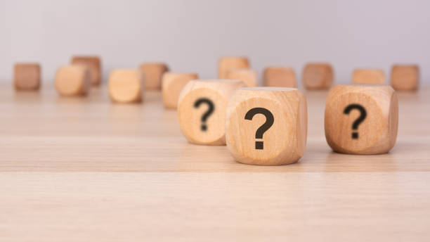istock three wooden blocks with question marks over a gray background with copy space 2205697747