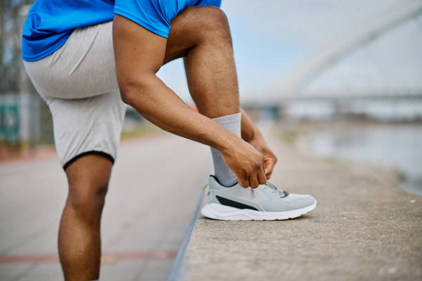 istock Sportsman tying his running shoes before a workout 2205698329