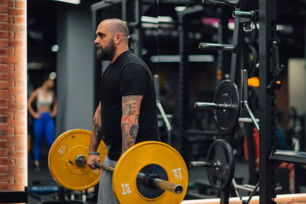 istock Strong male bodybuilder lifting weights in modern gym 2205698525