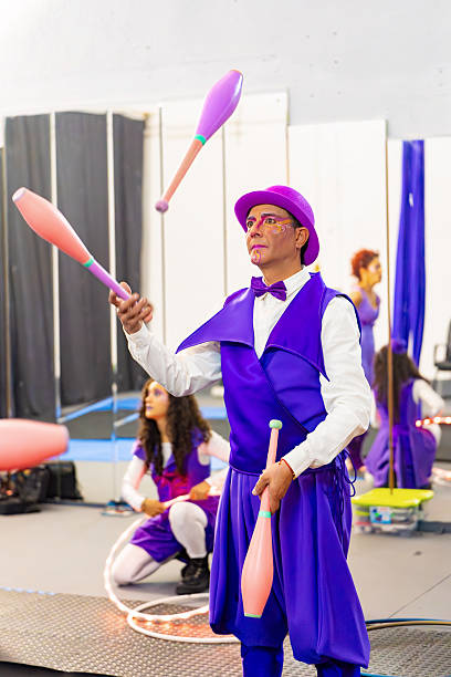 Juggler is showcasing their skills with colorful clubs during a circus training session