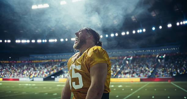Side view of boy wearing American football helmet showing biceps under colorful neon lights at home in the evening