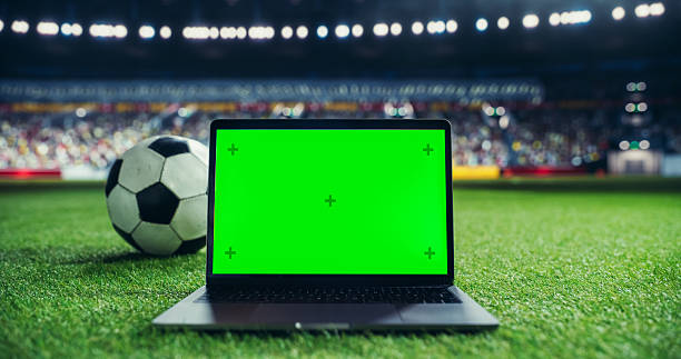 istock Laptop Computer with a Green Screen Placed on Grass Next to a Soccer Ball in a Stadium, Suitable for Mockups and Sports Marketing. Ideal Setup for Showcasing Digital Content in a Sports Environment 2205704991