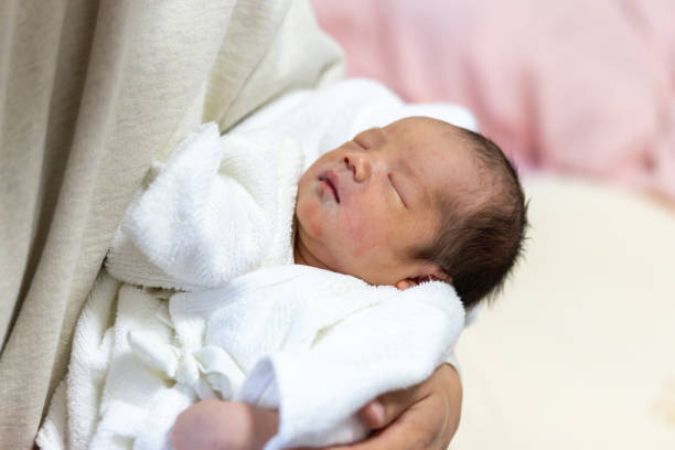 istock Father holding his sleeping newborn baby just born yesterday 2205709609