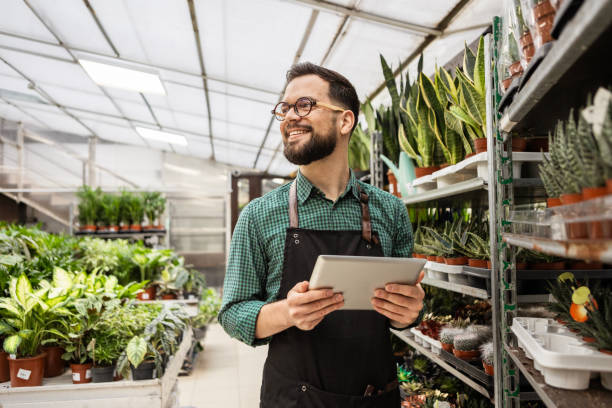 istock Man Tending to Beautiful Indoor Plants Using Digital Tablet 2205711474