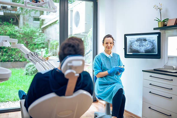 istock Dentist showing x-ray image to her patient. 2205711789