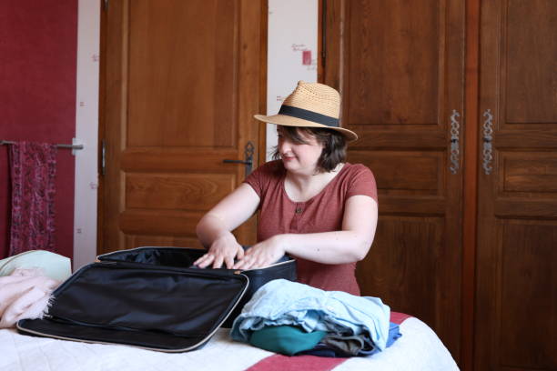 istock A woman squatting is packing for a trip 2205712749