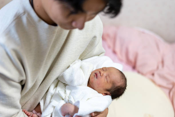 istock Father holding his sleeping newborn baby just born yesterday 2205713122
