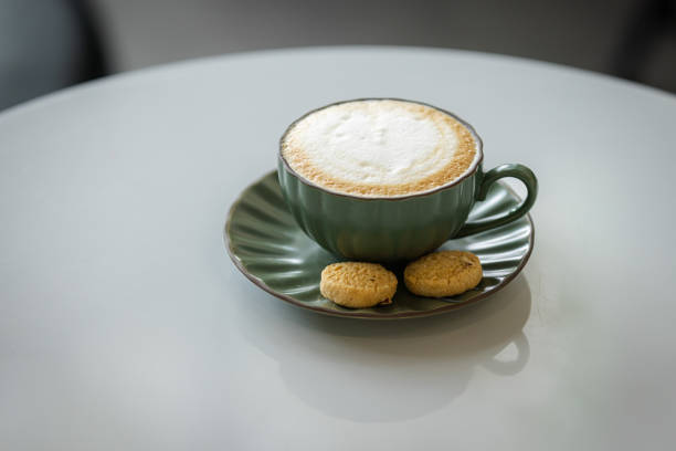 Hot latte with serving cookies at coffee shop.