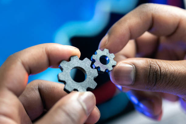 istock Hands holding and connecting two metal gears in a collaborative concept 2205715346