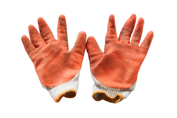 orange work gloves with visible dirt and wear, isolated against a white background. Represents manual labor, protection, and the tools of trade.
