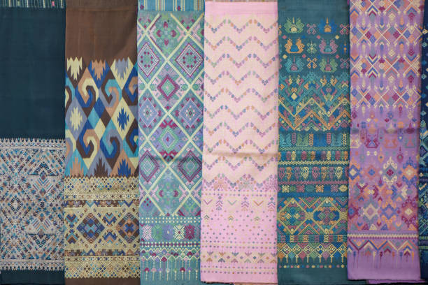 display of traditional Thai silk fabrics featuring intricate designs and vivid colors. Each piece showcases unique patterns, blending vibrant geometric shapes and delicate floral motifs.