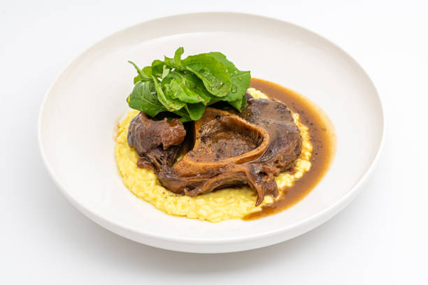 istock Gourmet osso buco with saffron risotto and fresh greens on a plate 2205717788