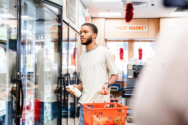 istock Young Man Grocery Shopping, Selecting Items in a Cooler 2205717806