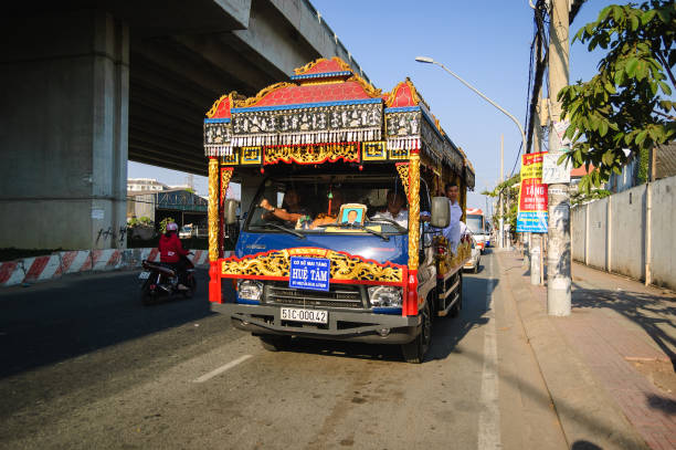 Ho Chi Minh City, Vietnam - February 5, 2015: A traditional Vietnamese style hearse vehicle with lots of fancy decorations driving through the city to cemetery.